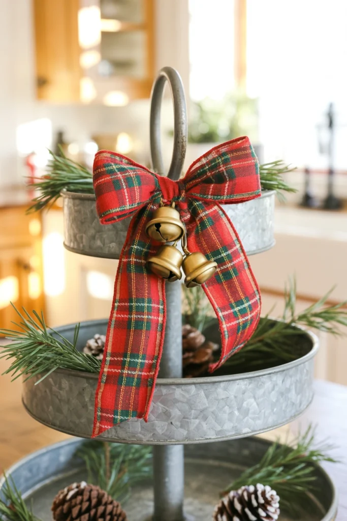 A large red-and-green plaid bow tied to the tray's carry handle with small gold jingle bells hanging from the ribbon tails