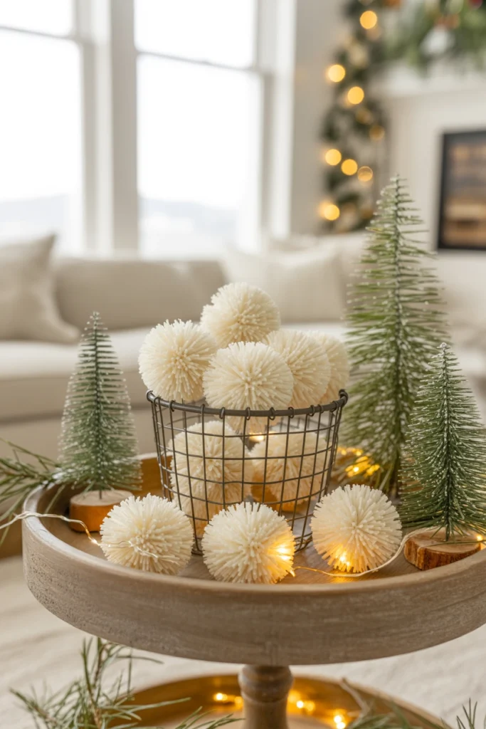 Small white faux snowball ornaments piled loosely in a wire basket on the bottom tier