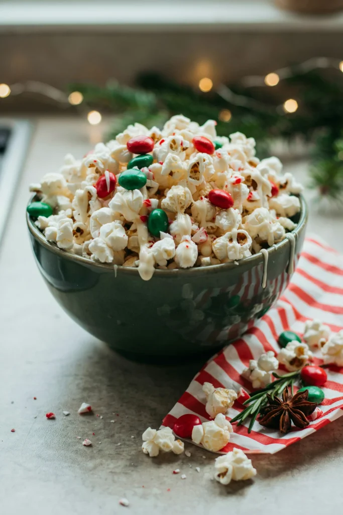 Christmas popcorn bar with white chocolate drizzle, red and green M&Ms, and crushed peppermint