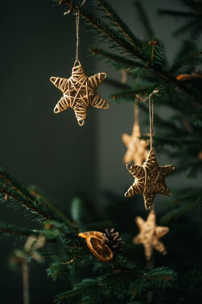 Handwoven golden straw star ornaments hanging on a Christmas tree