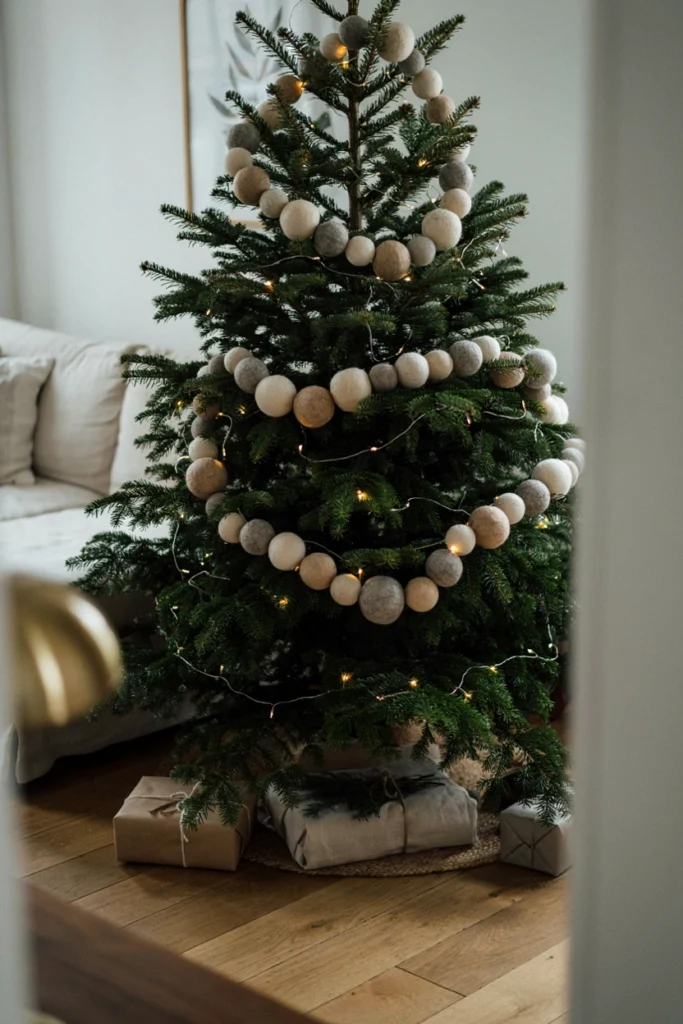Christmas tree decorated with a chunky cream and gray wool felt ball garland