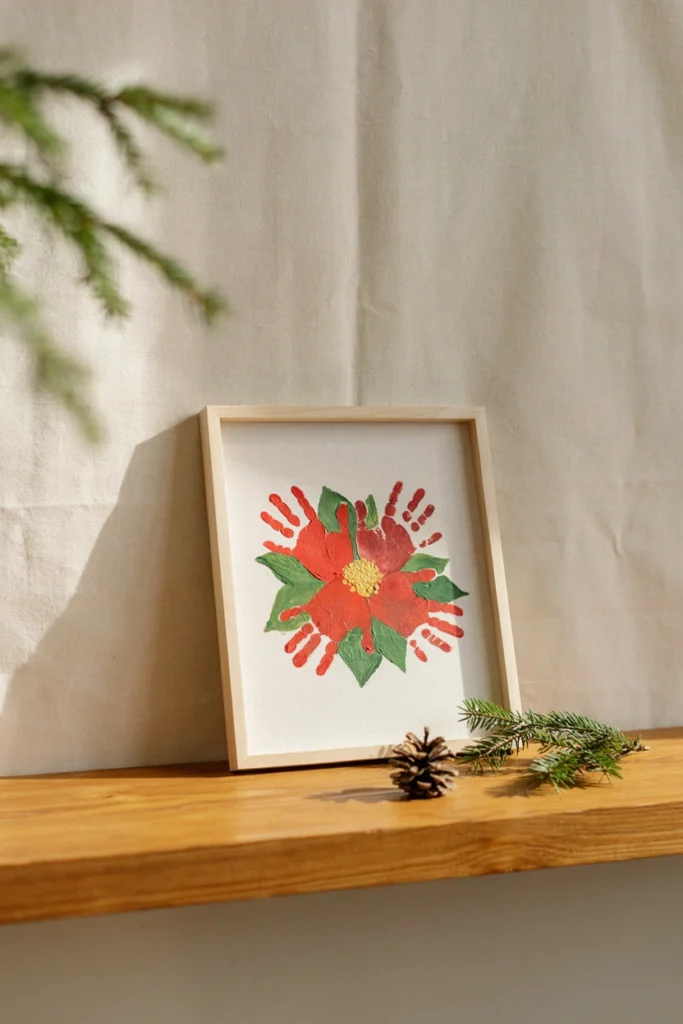 Red handprints arranged in a circular flower pattern with a yellow fingerprint center resembling a poinsettia