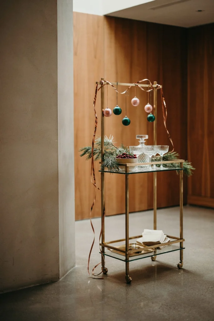 Rolling bar cart styled with copper garland, blush ornaments, and white pine branches