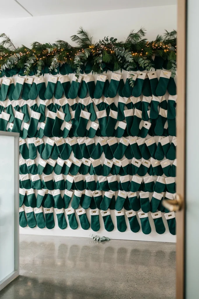 Wall of small felt stockings, each labeled with an employee's name, hung in neat rows near the office entrance