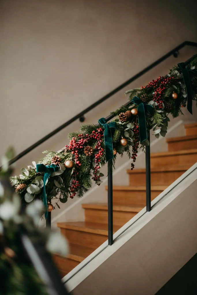Rustic garland strung with dried cranberries and small pine cones draped along a staircase railing
