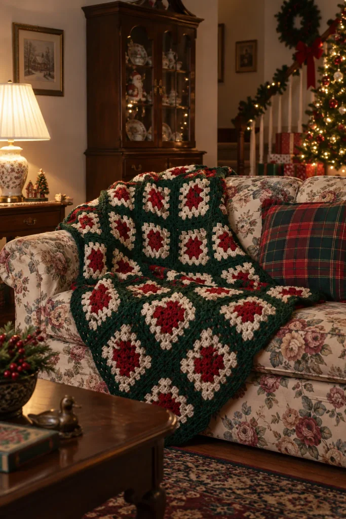 Red, green, and white granny square afghan draped over a floral sofa